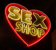 Neonskylt med hjärta bakom texten SEX SHOP för nattklubbsmiljö – Mini Dress Heart Rob White stylingtips