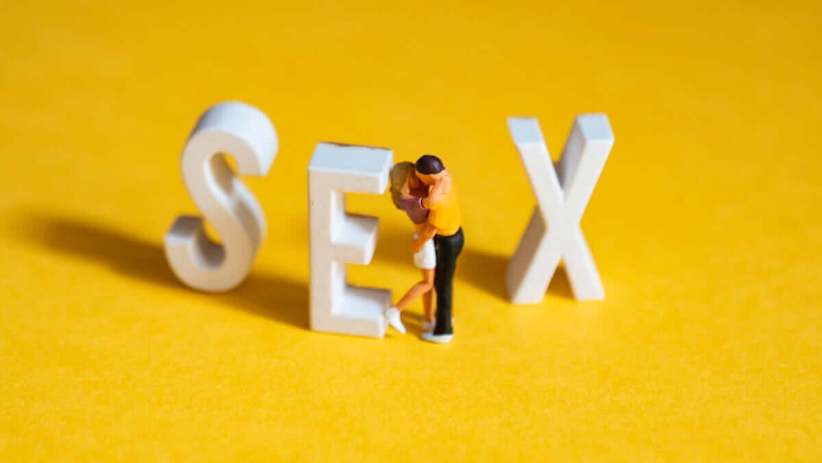 σημαία lgbt καραμέλα ξυλάκι με μινιατούρα ζευγάρι δίπλα σε γράμματα sex σε κίτρινο φόντο