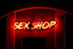 Neoonreklaam “SEX SHOP” pimedal tänaval – Enjoy The Moment võrgukeha erootikapoodide visuaalne bränding