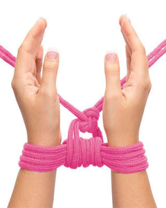 Rosa bondage-rep runt handleder, händer uppbundna framför kroppen, sensuell bild för bondage time kollektion