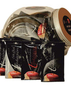 Tentation Monodose Lubricant set with black fruit-flavoured sachets, red fruit graphics and a clear jar with a brown lid.
