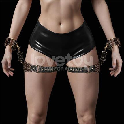Rebellion Reign thigh cuffs set in black PU with bronze metal buckles, adjustable straps, wrist cuffs, and attachment clips