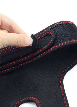Adjustable Strap on black fabric harness with red zigzag stitching and a hook-and-loop fastening tab