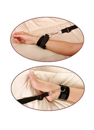 Bed Bindings Restraint Kit with black nylon straps, padded cuffs and metal clips shown secured around a wrist and ankle.