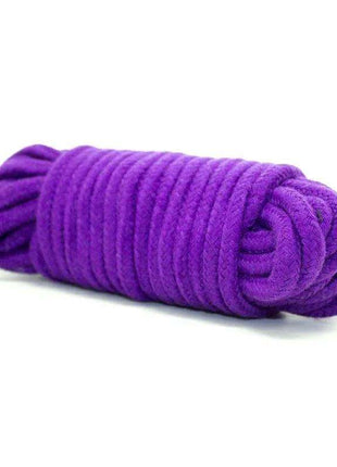 Bondage Set 10 Pieces Purple featuring a vivid purple soft braided rope, tightly coiled into a compact bundle