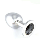 Butt plug with a polished silver-tone metal shaft, rounded tip and a large dark faceted gem set in its flared base.