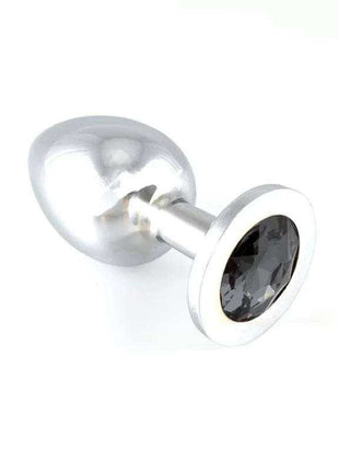Butt plug with a polished silver metal shaft, rounded tapered tip and wide base set with a dark faceted gem