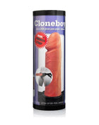 Cloneboy Dildo kit with a flesh-toned silicone mold and harness strap shown on the cylindrical package