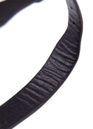 Collar with Bell in black textured material, shown as a curved adjustable strap with a ridged surface.