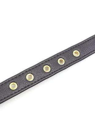 Collar with Bow and Rattle featuring a black textured strap with gold-tone metal adjustment eyelets; no bow or rattle visible