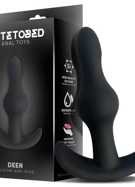 Deen Silicone Butt Plug in black silicone with a smooth tapered body and wide curved anchor base beside its retail box