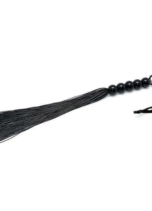 Flogger 38 cm with black thin flexible strands, glossy black beaded handle and a looped wrist strap.