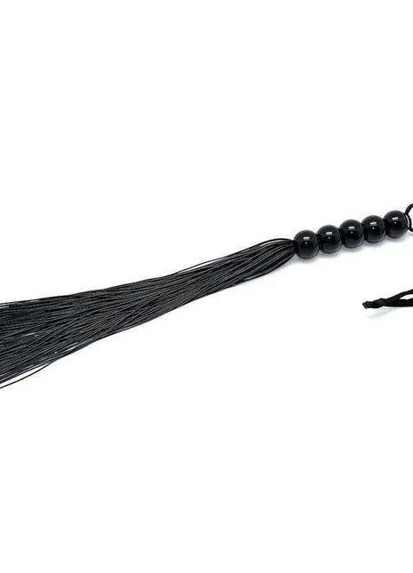 Flogger 38 cm with black thin flexible strands, glossy black beaded handle and a looped wrist strap.