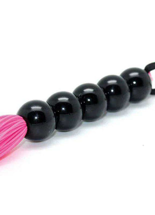 Flogger Silicone Pink with bright pink flexible strands, glossy black bead handle and a black wrist loop