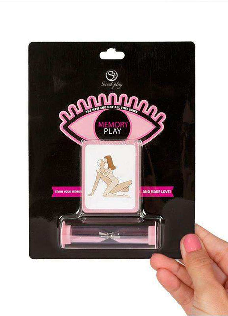Game Memory Play card set with black packaging, pink eye-shaped graphics, a suggestive illustrated card and pink hourglass