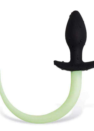 Glow in the Dark silicone dog tail butt plug with a curved pale green glowing tail and black flared base