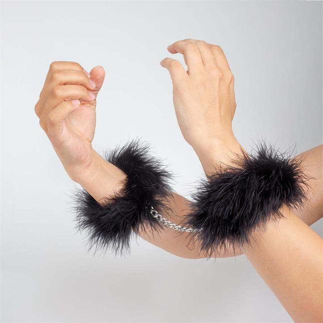 Black handcuffs adorned with soft marabou feathers for elegant intimate play