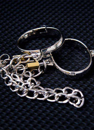 Metal Hand Cuff in shiny silver metal with two hinged circular cuffs, clasp details, and an attached chain