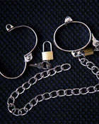 Metal Hand Cuff in shiny silver-tone metal, featuring open circular bands, clasp details, and a long linked chain.