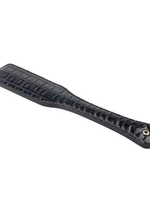 Paddle Spank Me 32 cm, a black glossy paddle with a textured, segmented surface and a small metal eyelet at the handle