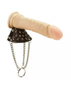 Parachute Ring with Spikes featuring a black studded cone, dangling silver chains and ring, and a beige handle