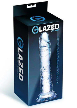 Realistic Dildo in clear crystal with a lifelike shape, textured veins and flared base, shown on product packaging