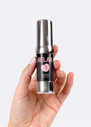 Relax! Anal Gel in a silver pump bottle with a black label, pink lettering and a pink heart logo, held in a hand