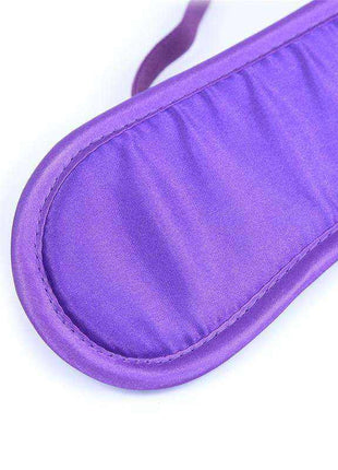 Satin Blindfold Purple with a smooth, shiny purple fabric surface, padded oval shape, stitched edges and matching strap