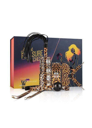 Secret Pleasure Chest with a dark illustrated box, leopard-print restraints and accessories, black cords, and gold-tone details