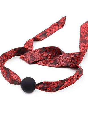 Silicone Ball Gag Red/Black with a matte black ball and red-and-black floral patterned fabric straps