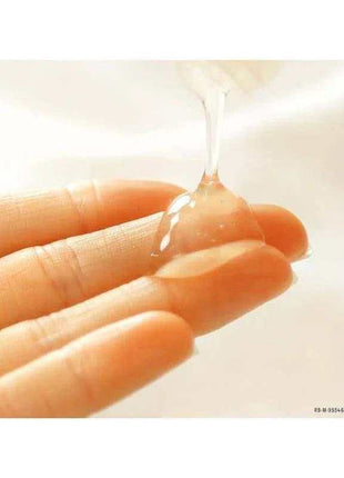 Silicone Base Lubricant shown as a clear, glossy gel being poured onto fingertips, with a smooth liquid texture.