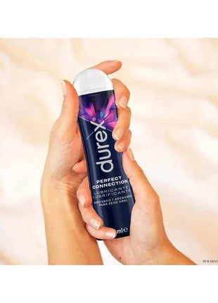 Silicone Base Lubricant in a dark blue 50 ml bottle with a white cap and colorful starburst label, held in one hand